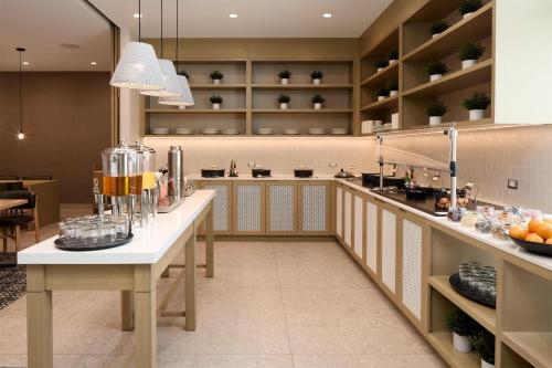 a large kitchen with two tables in a room at Hyatt Place Montreal Airport in Dorval