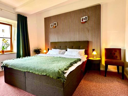a bedroom with a large bed and a chair at Hotel Bergen Zur Post by Rikas Hotels in Bergen