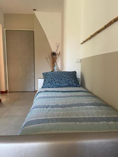 a bedroom with a bed with a blue and white comforter at CasaNobile - Suite Il Grano in Merate