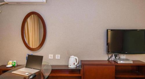 a room with a desk with a television and a laptop at GreenTree Inn Nanning Langdong Hotel in Nanning
