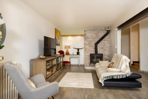a living room with two chairs and a fireplace at Maison spacieuse & calme à 9 min de la Cité in Carcassonne