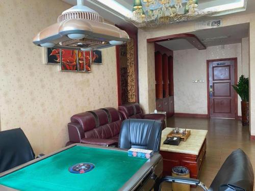 a room with a pool table and leather chairs at Shenzhen Kai Long International Hotel in Shenzhen