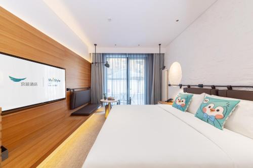 a bedroom with a large bed and a projection screen at Hefeng Xinyi Hotel Beijing Jinsong Guangqumenwai Subway Station Branch in Beijing