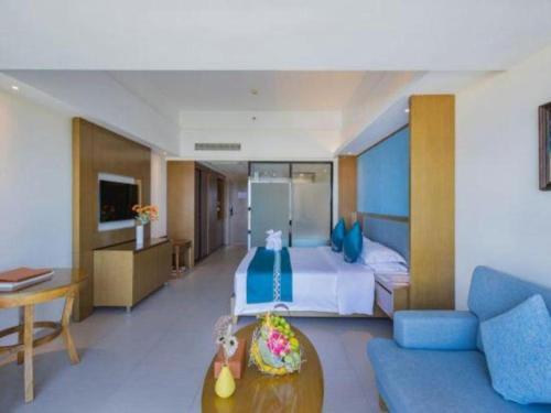a hotel room with a bed and a couch at Da Peng Zhongzhou Hotel in Haikou