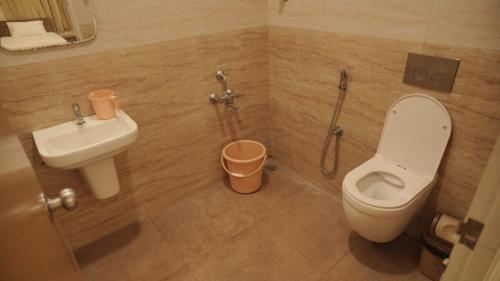 a bathroom with a toilet and a sink at Ganesh Residency 
