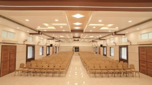 an empty hall with rows of chairs in it at Ganesh Residency 