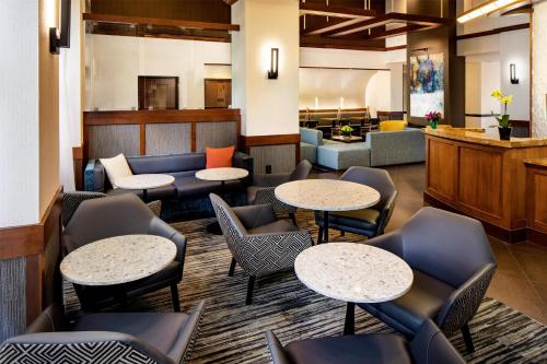 a lobby with tables and chairs and a waiting room at Hyatt Place Roanoke Airport / Valley View Mall in Roanoke