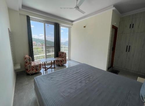 a bedroom with a large bed and a large window at The Refuge Inn in Lakhwār