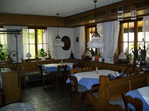 a restaurant with two tables and chairs and windows at Hotel Gasthof Traube in Kernen