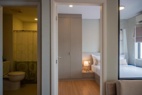a bathroom with a toilet and a room with a bed at PhnomPenh Apartment by The Star Polaris 23 Condo in Phnom Penh