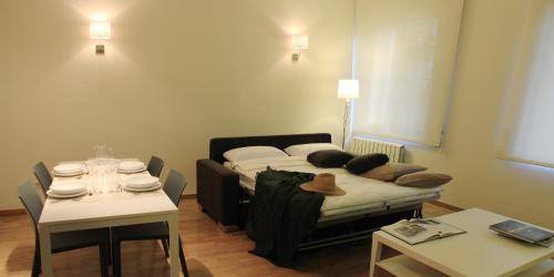 sala de estar con cama, mesa, mesa y sillas en Alguera Apartments Napols, en Barcelona