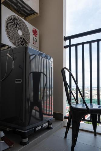 a black chair and a fan on a balcony at PhnomPenh Apartment by The Star Polaris 23 Condo in Phnom Penh