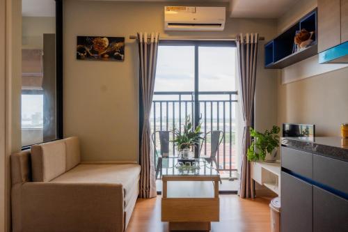 a living room with a couch and a balcony at PhnomPenh Apartment by The Star Polaris 23 Condo in Phnom Penh