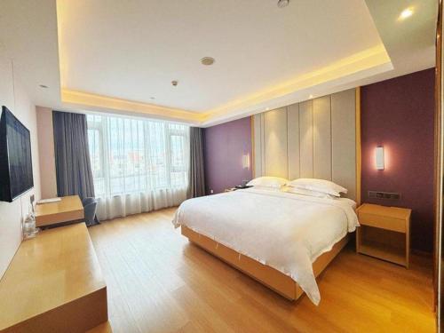 a bedroom with a large bed and a large window at Lavande Hotel·Dongxing Port in Fangcheng