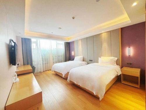 a hotel room with two beds and a television at Lavande Hotel·Dongxing Port in Fangcheng