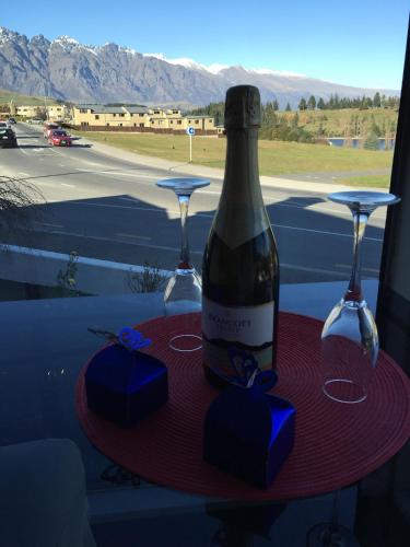 a bottle of wine and two glasses on a table at Hurley's of Queenstown in Queenstown