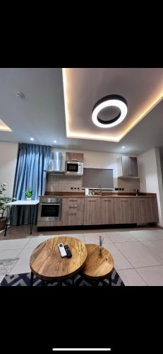 a kitchen with two wooden tables in a room at Park Apartments in Accra