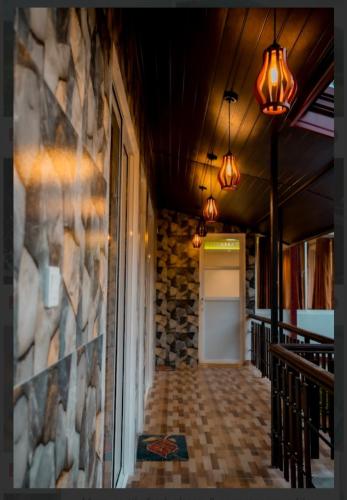 a hallway of a building with a door and lights at Rainforest Holiday Inn in Deniyaya