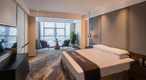 a hotel room with a large bed and a television at Grand Metropark Hotel Chongqing in Chongqing