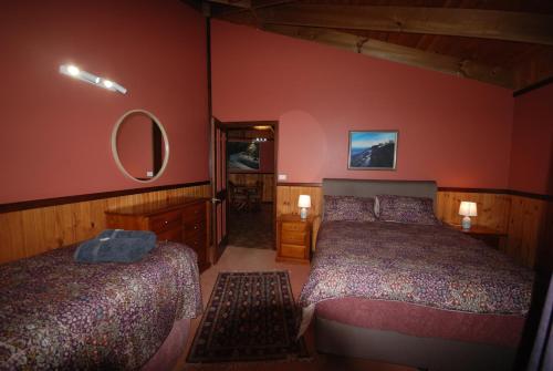 a bedroom with two beds and a mirror at Wrenwood Chalets in Augusta