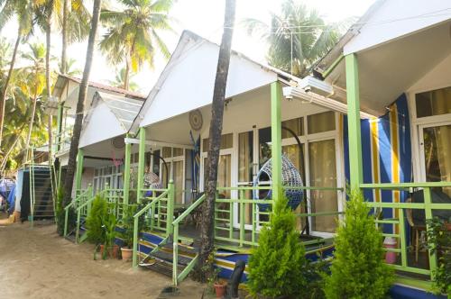 a row of houses with palm trees in the background at SUNBATH beach EXOTICA in Canacona
