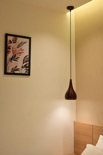a bedroom with a pendant light hanging from the wall at Saba's Courtyard in Kolachel