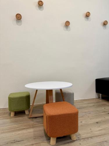 a table and two stools in front of a wall at 山有巷宅 Alley House in Puli