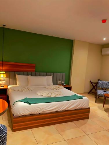 a bedroom with a large bed with a green wall at Pyramids Nomad View Hotel in Cairo