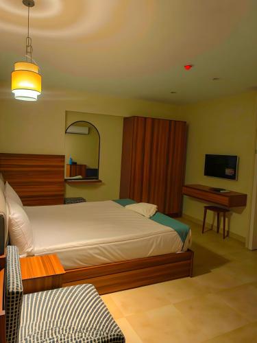 a bedroom with a bed and a desk and a television at Pyramids Nomad View Hotel in Cairo