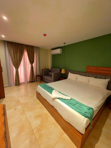 a bedroom with a large bed with a green wall at Pyramids Nomad View Hotel in Cairo