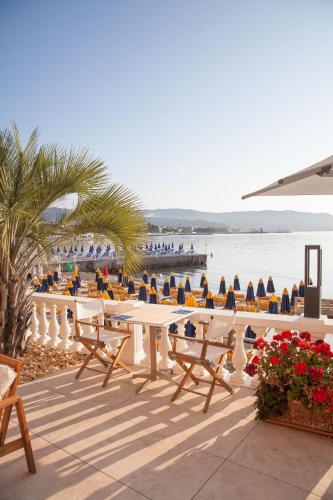 ディアーノ・マリーナにあるHotel Golfo e Palmeの水辺のテーブルと椅子