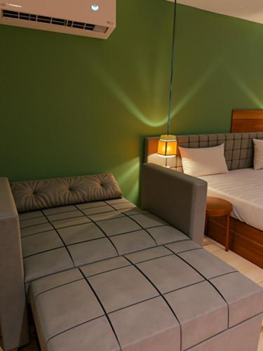a room with two beds and a green wall at Pyramids Nomad View Hotel in Cairo