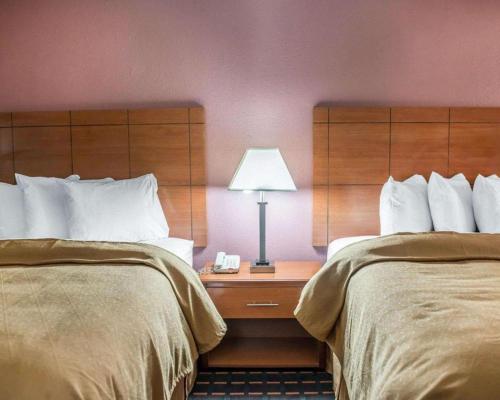 a hotel room with two beds and a table with a lamp at Quality Inn in Marianna