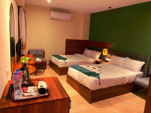 a hotel room with two beds and a table at Pyramids Nomad View Hotel in Cairo