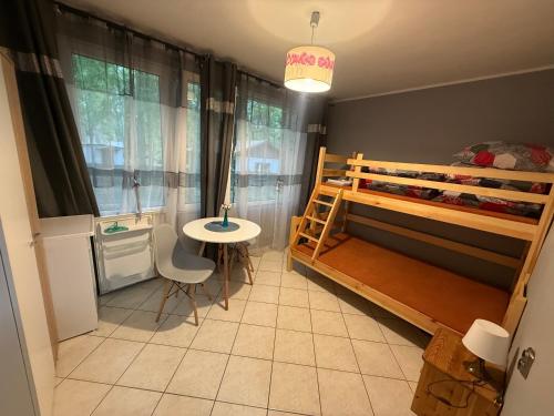 a small room with a bunk bed and a table at POD SOSNAMI Ośrodek Wypoczynkowy Boszkowo Letnisko in Boszkowo