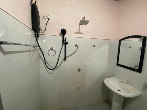 a white bathroom with a sink and a mirror at GB Royal Stay Nuwara Wewa in Nikawatawana