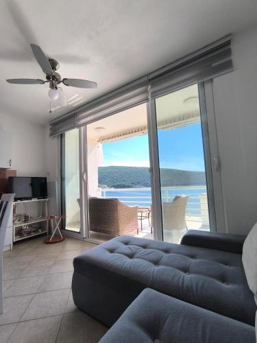 a living room with a couch and a view of the ocean at Seaside Apartment Kruče in Kruče