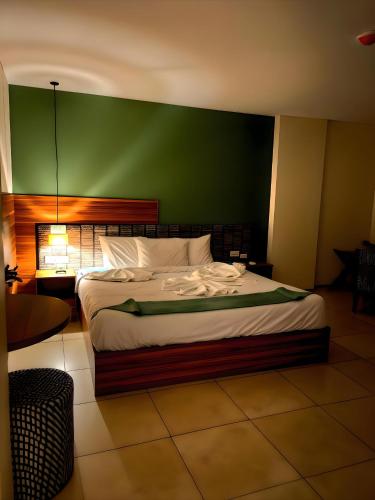 a bedroom with a large bed with a green wall at Pyramids Nomad View Hotel in Cairo
