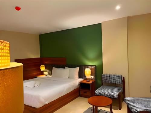 a bedroom with a bed and a green wall at Pyramids Nomad View Hotel in Cairo