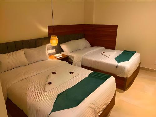 two beds in a hotel room with flowers on them at Pyramids Nomad View Hotel in Cairo