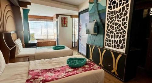 a hotel room with two beds and a tv at Phi Phi Nice Beach Hotel Hip in Phi Phi Don