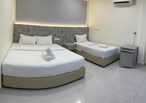 two beds in a room with two beds sidx sidx sidx sidx at D'Lima Beach Inn in Pantai Cenang