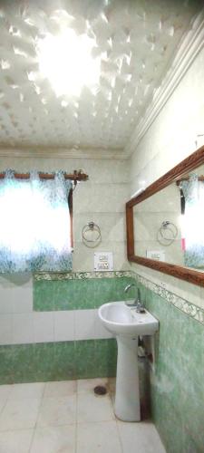 a bathroom with a sink and a mirror at Greenoriva - D2 - Greenery & Peace in Srinagar