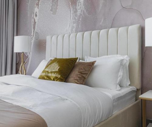 a bed with white sheets and pillows at Hanza Tower 22 WHITE Jacussi & Sauna & Pool & SPA in Szczecin