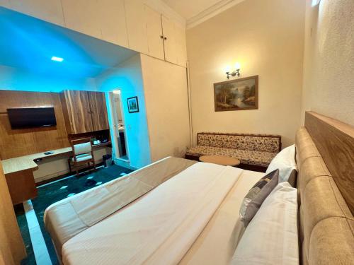a room with a bed and a couch in it at asar CP Outer Circle by Orion Hotels in New Delhi