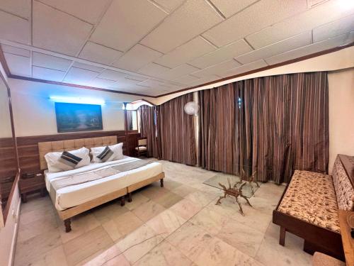 a large room with a bed and a couch at asar CP Outer Circle by Orion Hotels in New Delhi