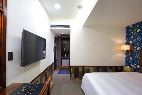 une chambre d'hôtel avec un lit et une télévision à écran plat dans l'établissement Han She Hotel, à Taipei