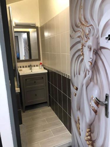 a bathroom with a door with a painting of a woman at House, lot, secure private parking in Issoudun