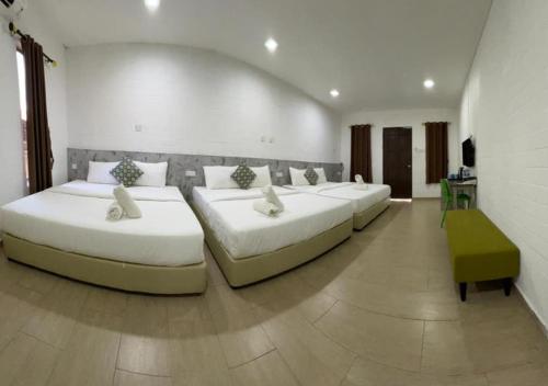 a room with four beds in a room at D'Lima Beach Inn in Pantai Cenang