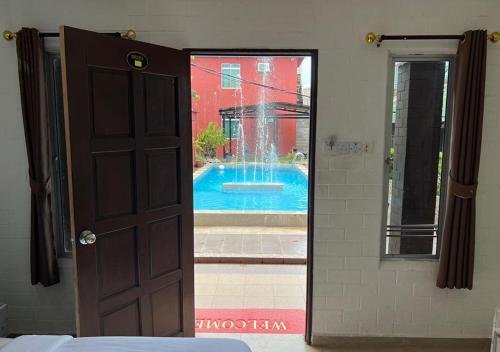 a door leading to a swimming pool through a window at D'Lima Beach Inn in Pantai Cenang